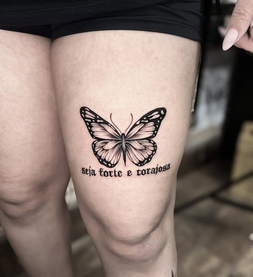 Tatuagem de borboleta com lettering na coxa